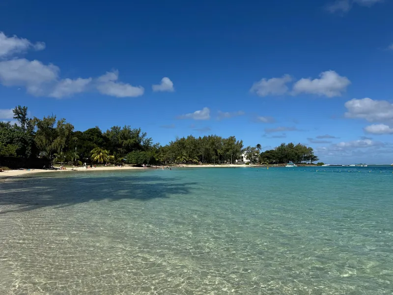 Playa soleada e islote verde en Blue Bay, Mauricio