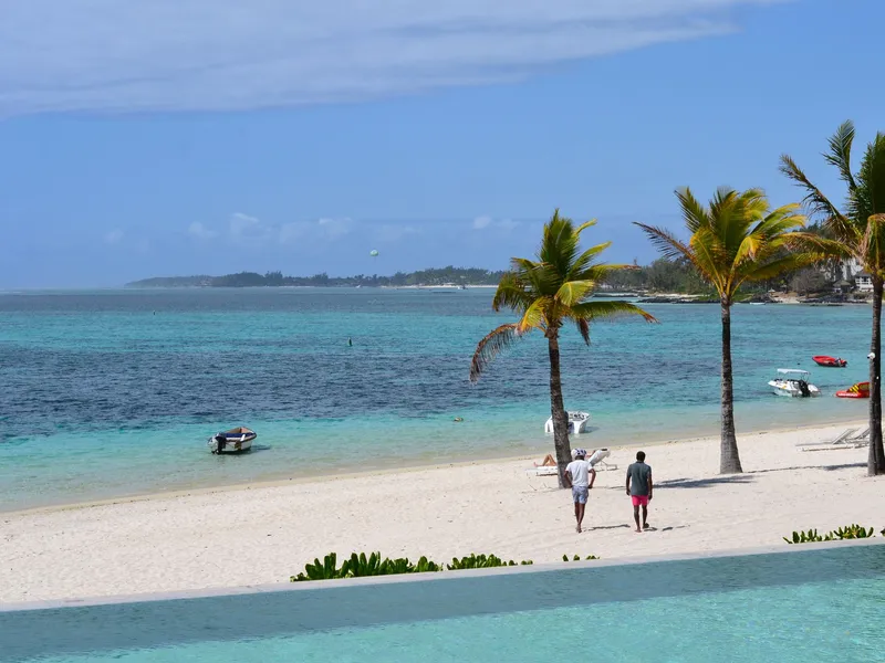 White sand beach with palm trees and a turquoise lagoon in Mauritius