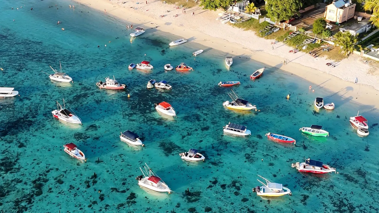 Vue aérienne de bateaux sur un lagon turquoise au bord d'une plage à Maurice