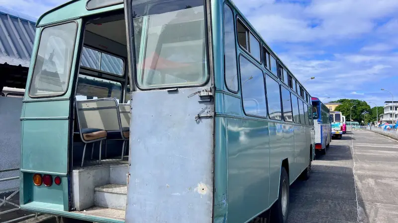 Un viejo autobús azul aparcado junto a la carretera
