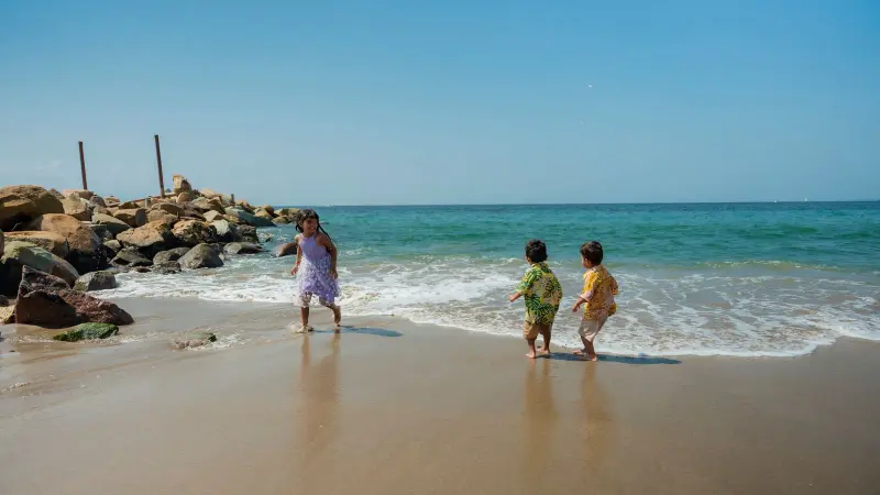 Niños jugando en las olas en una playa soleada