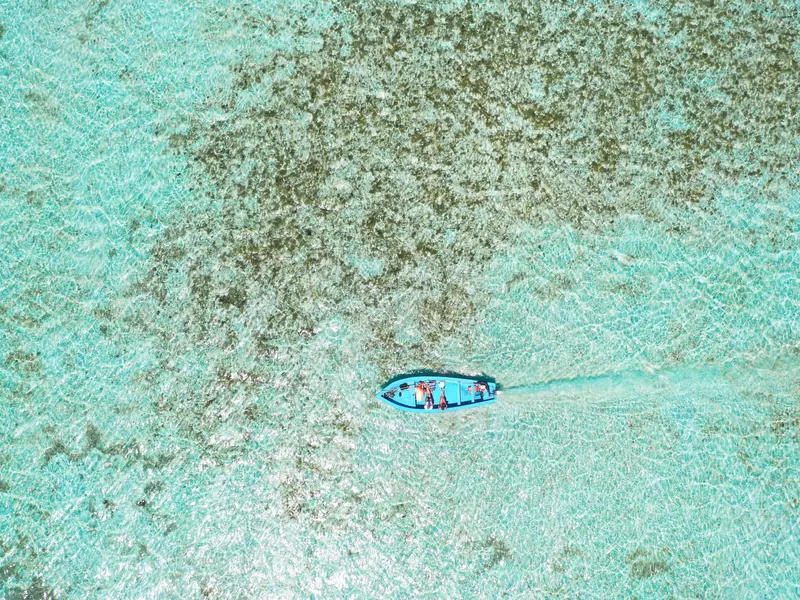 Pequeña barca en una laguna clara y poco profunda, vista desde arriba